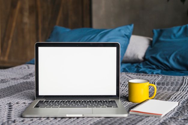 laptop-with-blank-white-screen-near-cup-spiral-notepad-bed_23-2147956440-1